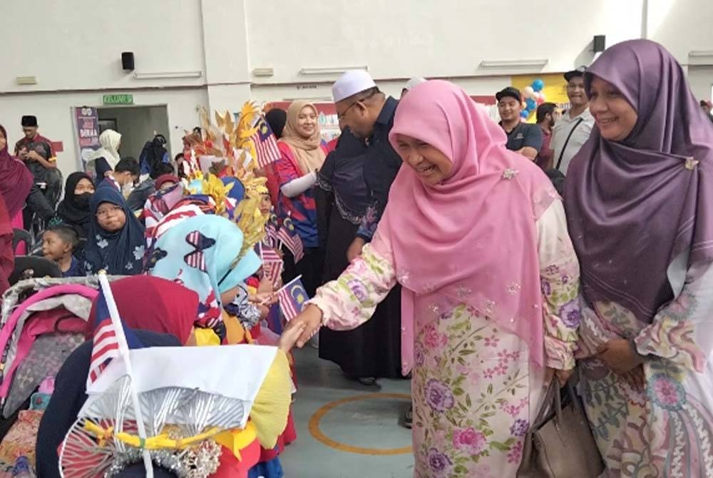 Dr Hafidzah bersalam dengan kanak-kanak yang mengambil bahagian dalam pertandingan pakaian bertemakan kemerdekaan.