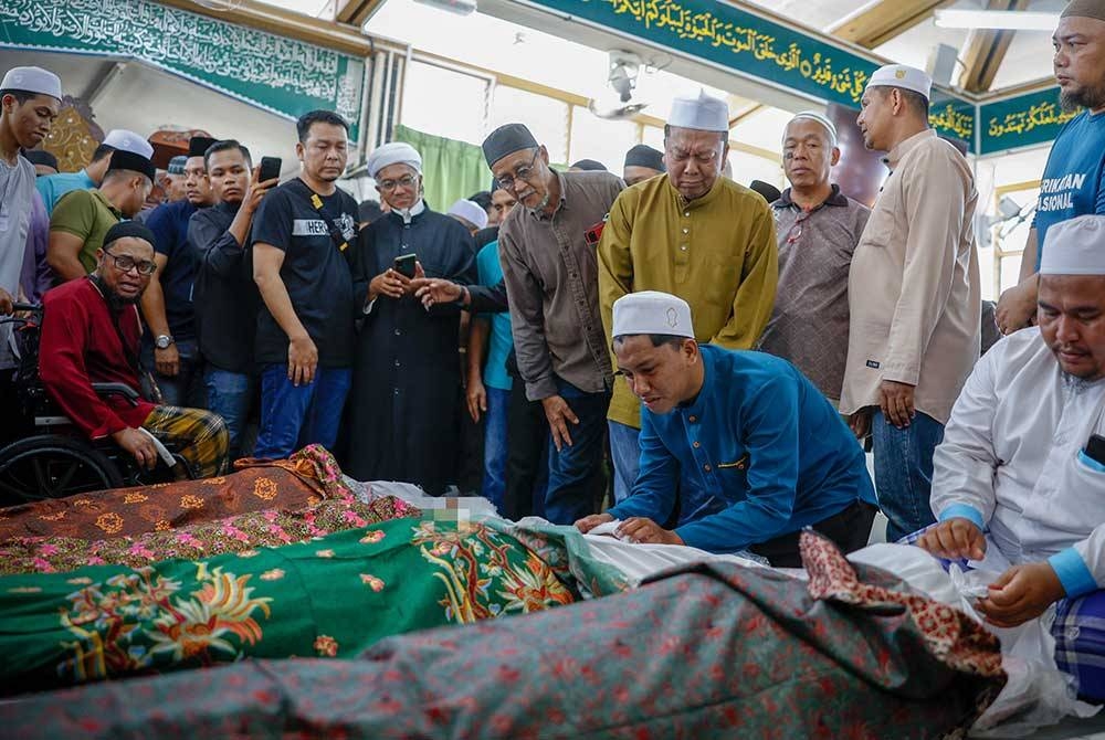 Anak sulung Abdurrahman Amir Ruddin, 19, meratapi wajah ibu bapa dan adik-adiknya yang meninggal dunia akibat kemalangan di Masjid Jamek Ubudiah dekat Parit Limbong, hari ini. - Foto Bernama.