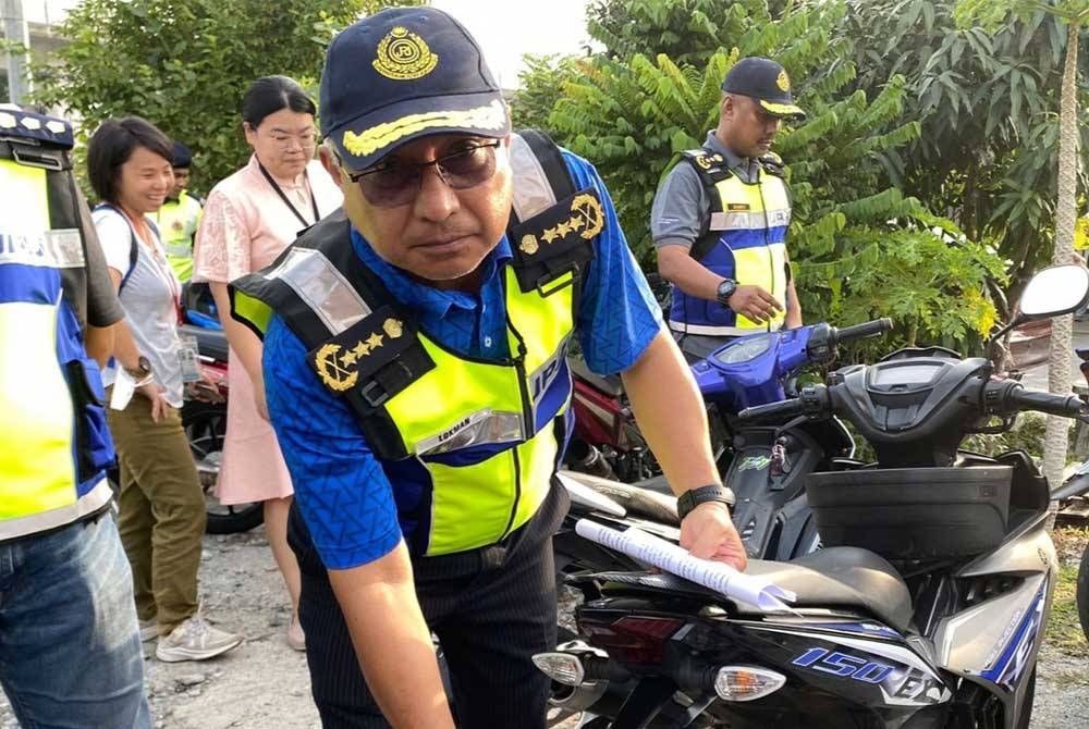 Lokman menunjukkan antara kesalahan pada motosikal yang ditahan menerusi operasi dijalankan di Taman Puchong Perdana di sini pada Sabtu.