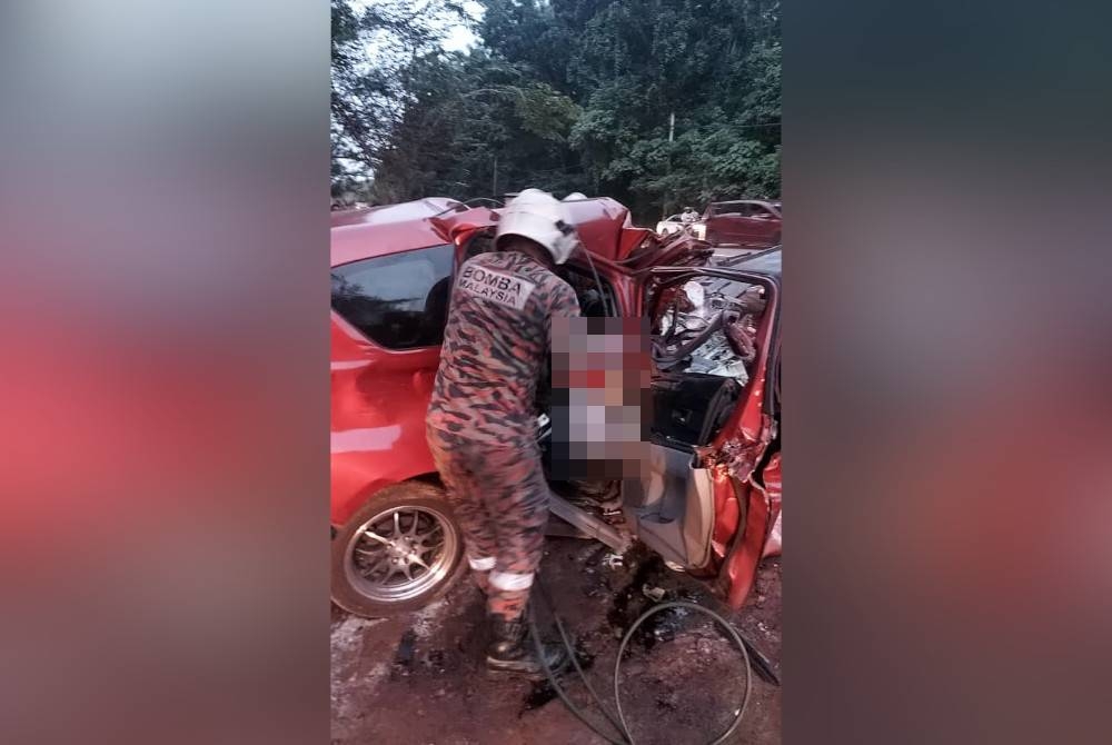 Anggota bomba mengeluarkan mangsa kemalangan yang tersepit berhampiran Taman Yayasan, Jalan Segamat-Kuantan, petang Jumaat.