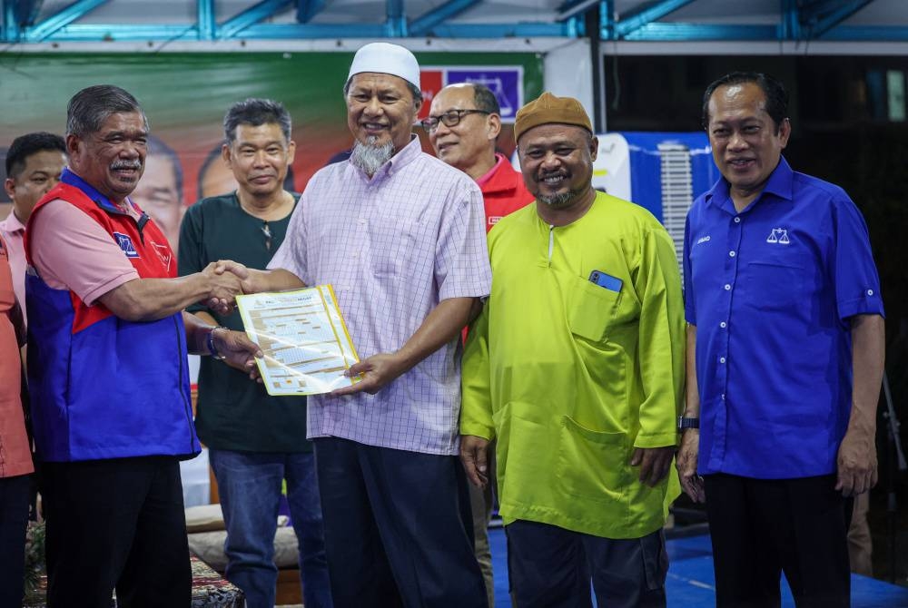 Mohamad (kiri) menerima borang keahlian daripada Najib (tiga kanan) pada Ceramah Kelompok Perpaduan sempena PRK DUN Simpang Jeram di Taman Desa, Muar pada malam Sabtu. - Foto Bernama