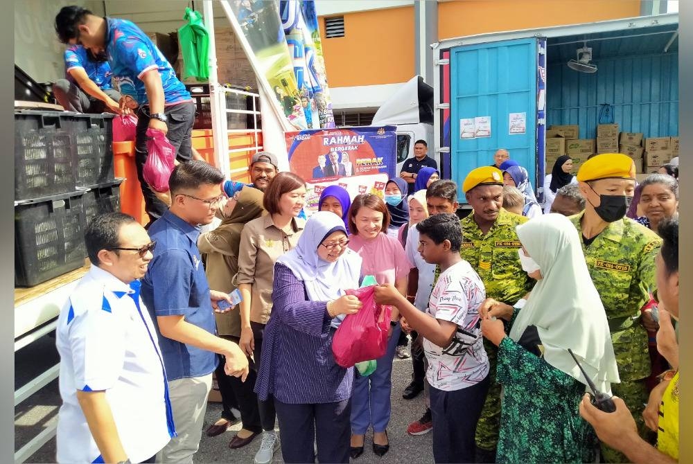 Fuziah (tiga dari kiri) membuat gimik jualan ayam RM1 seekor kepada orang ramai yang hadir ke Program Jualan Rahmah Bergerak Peringkat Negeri Perak di Dewan Bandaran Gopeng di sini pada Ahad.