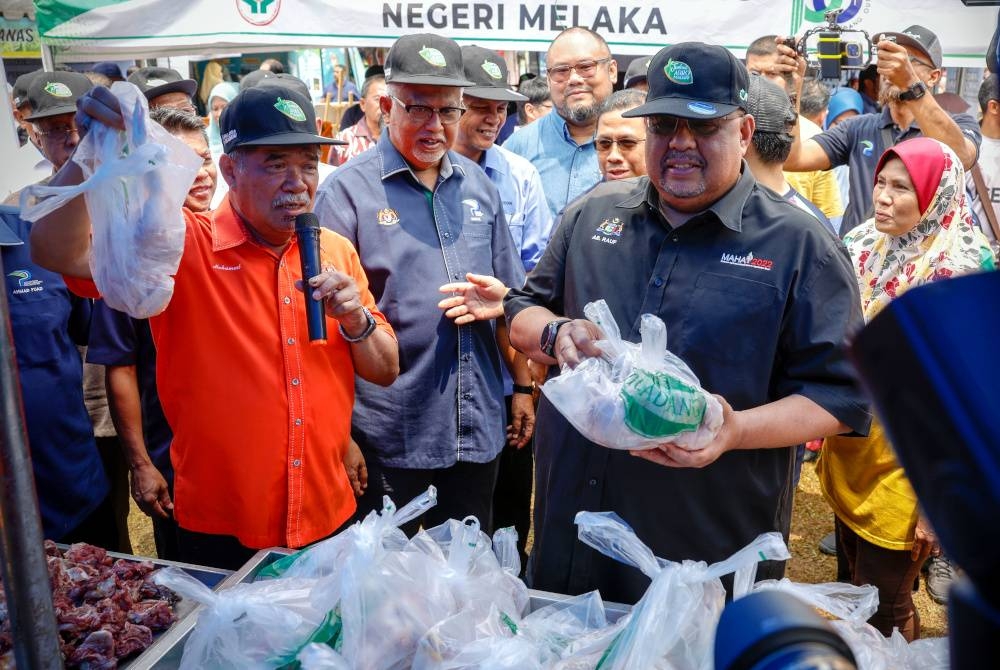 Mohamad (kiri) membuat pengumuman jualan lelong ayam dengan harga RM6.60 seekor pada Karnival Jualan Mega Agro Madani Peringkat Kebangsaan 2023 di Dataran Sejarah dekat Ayer Keroh pada Ahad. - Foto Bernama