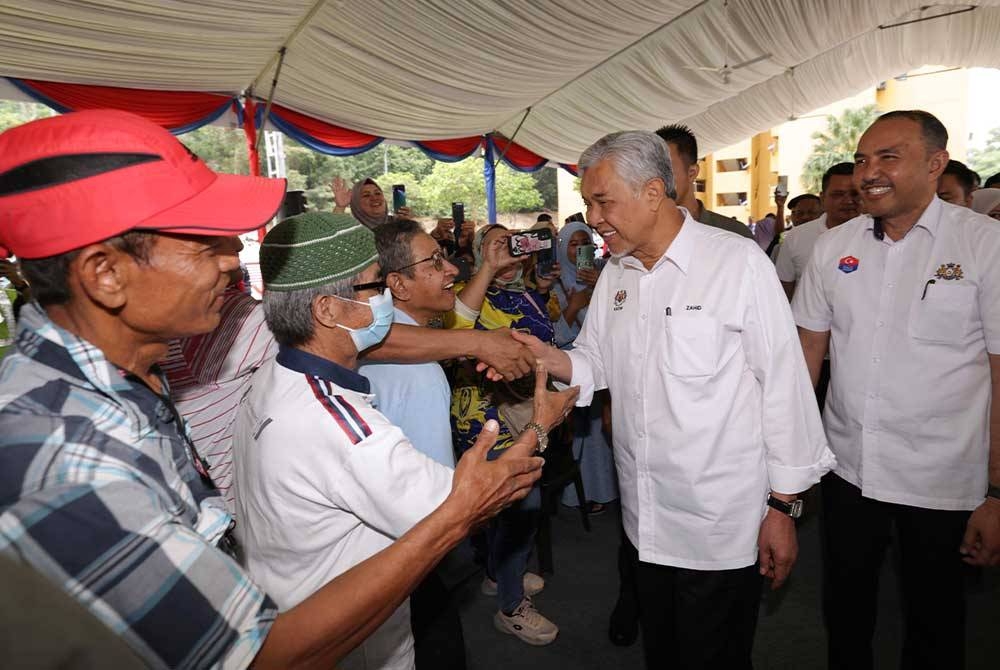 Ahmad Zahid diiringi Mohd Jafni (kanan) bersalaman dengan para penduduk ketika hadir pada Program Bersama Rakyat di PPR Kempas Permai, Johor Bahru hari ini. - Foto Bernama