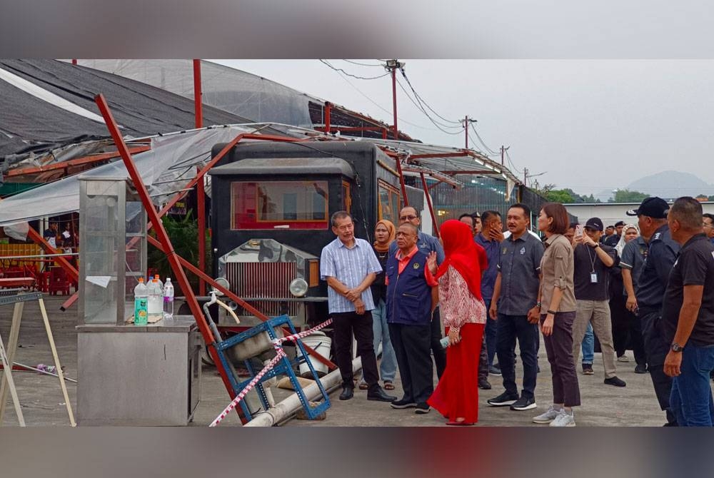 Saarani (dua dari kiri) melihat keadaan bumbung yang menempatkan 36 peniaga runtuh akibat ribut di Ipoh Night Market.