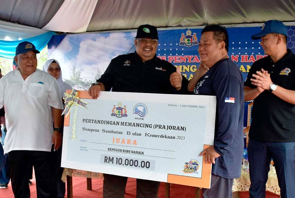 Ab Rauf (dua kiri) menyampaikan hadiah wang tunai sebanyak RM10,000 kepada juara memancing Mohd Nazri Choo Abdullah (dua dari kanan) pada Majlis Penyampaian Hadiah Pertandingan Memancing (Pra Joran) dan Memasak Sempena Bulan Kemerdekaan 2023 di Sungai Melaka Fasa Dua pada Ahad. - Foto: Bernama