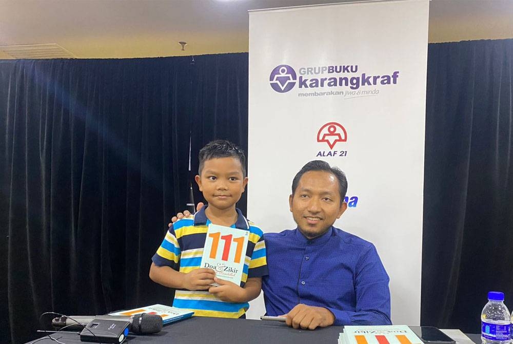 Abd Razak (kanan) bersama salah seorang pembeli cilik berusia 8 tahun.