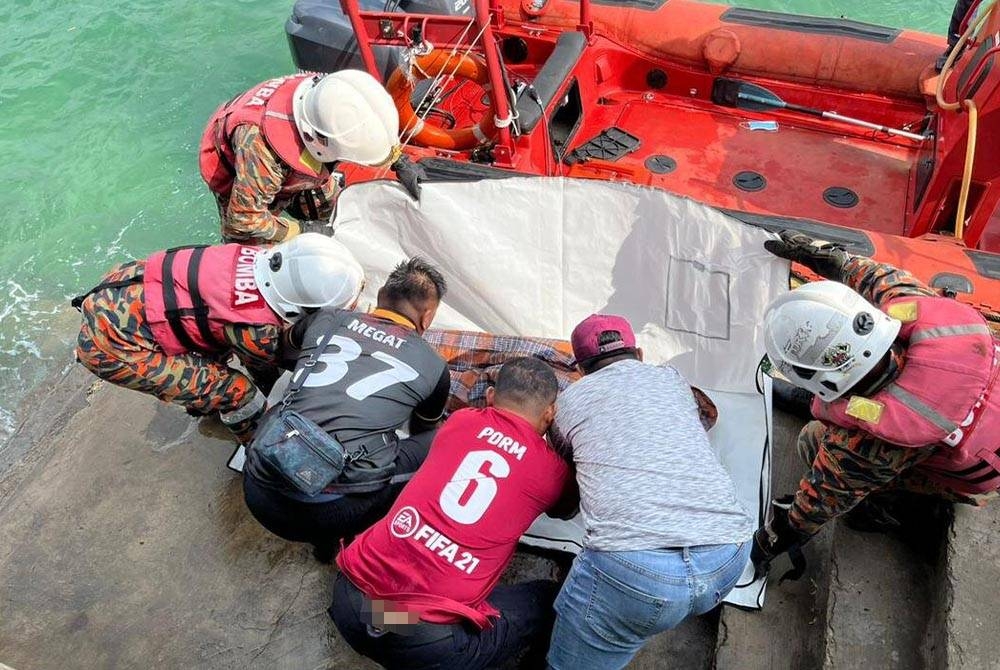 Pasukan bomba membawa naik mayat seorang lelaki yang terapung di perairan berhampiran Jeti Balembang, Pulau Bum-Bum, Semporna.