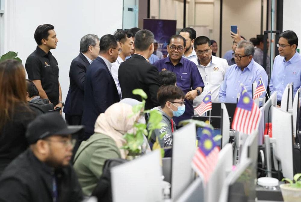 Mohamed Khaled (empat dari kanan) melawat Oppstar Berhad di Bangunan 12U, Sains@USM di Bukit Jambul pada Isnin.