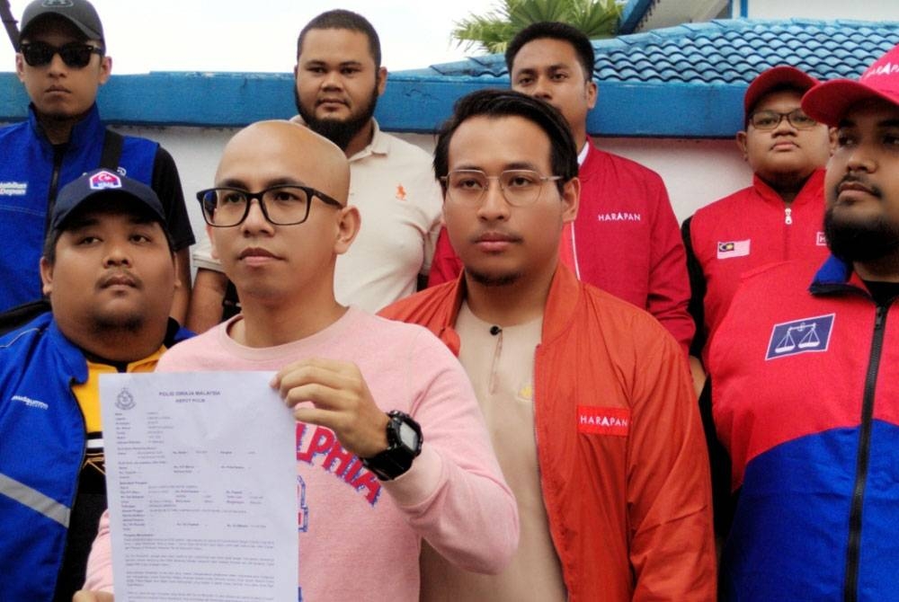 Mohd Harith (hadapan, dua dari kiri) dan Fadhli Umar (kiri) pada sidang media setelah membuat laporan polis di Balai Polis Tampoi, pada Isnin.