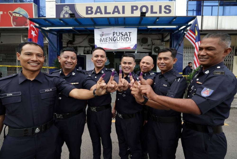 Anggota polis menunjukkan jari selepas menunaikan tanggungjawab mengundi awal bagi PRK Parlimen Pulai di Pusat Mengundi Balai Polis Kempas pada Selasa. - Foto Bernama.