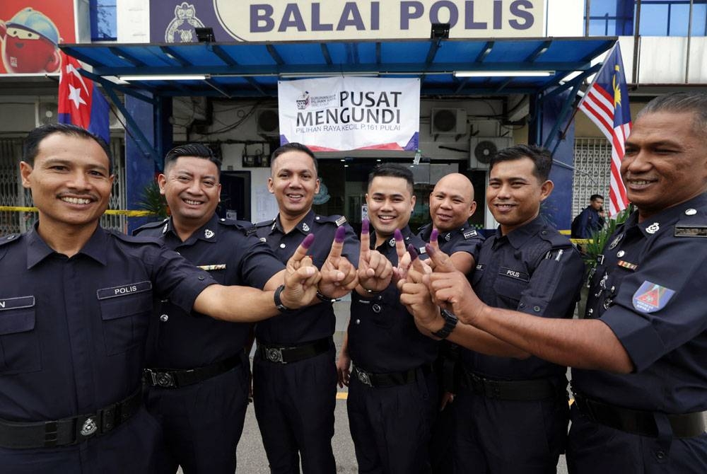 Anggota polis menunjukkan jari selepas menunaikan tanggungjawab mengundi awal bagi Pilihan Raya Kecil Parlimen P.161 Pulai di Pusat Mengundi Balai Polis Kempas pada Selasa. - Foto: Bernama