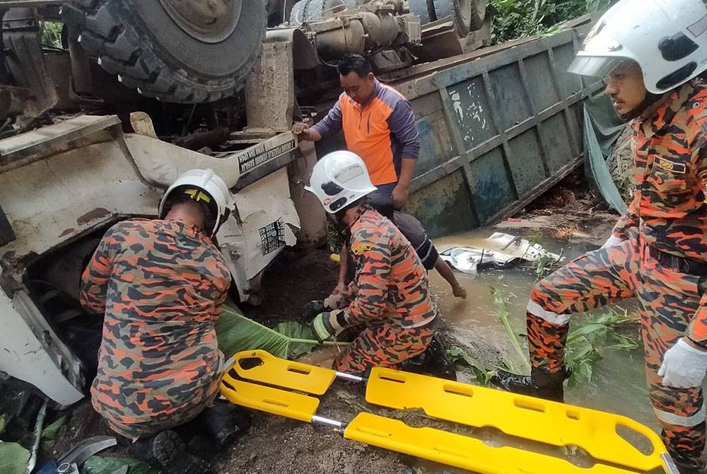 Pasukan bomba melakukan operasi mengeluarkan mangsa yang tersepit di dalam lori di Jalan Tun Fuad, Ladang Sungang, Kunak.