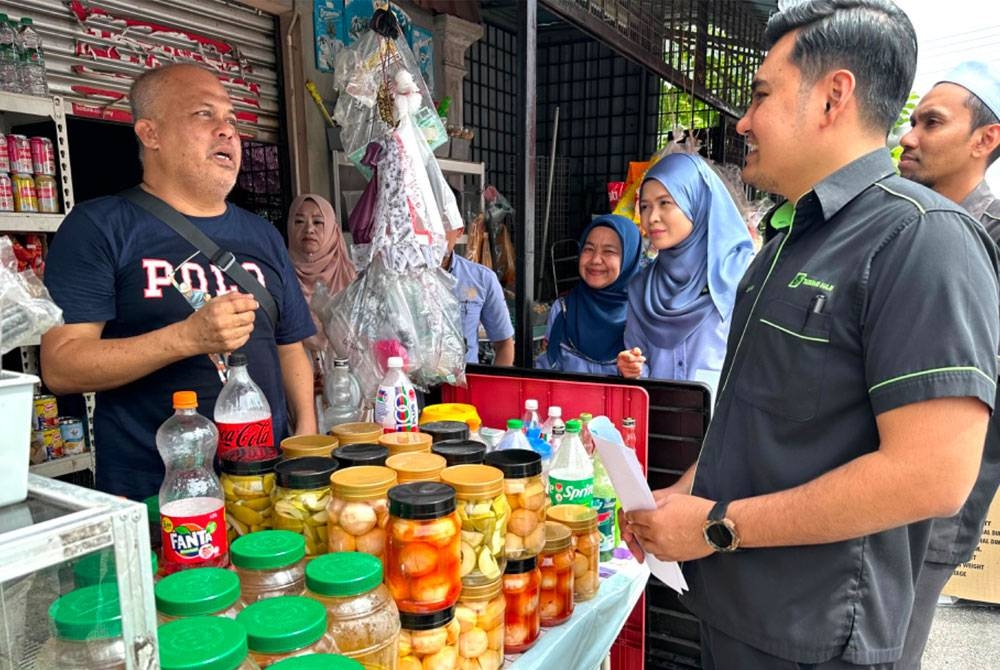 Nora (tiga dari kanan) dan Abdullah yang hadir ke kedai runcit Kamarudin (kiri) pada Selasa.