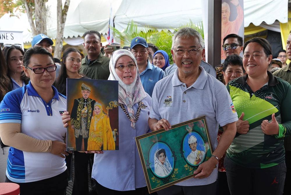 Al-Sultan Abdullah dan Tunku Azizah berkenan membeli beberapa lukisan, hasil kerja tangan oleh orang kurang upaya (OKU) pekak dan bisu Rosemary Yvonne Marcus ketika berangkat pada Majlis Santapan dan Ramah Mesra Bersama Rakyat sempena Kembara Kenali Borneo di Institut Perhutanan Telupid hari ini. - Foto Bernama