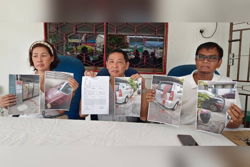 Leong Pan (tengah) bersama Mohd Rawi (kanan) menunjukkan gambar kereta yang terkena cat merah dan laporan polis yang dibuat selepas rumah diganggu along, Ahad lalu.