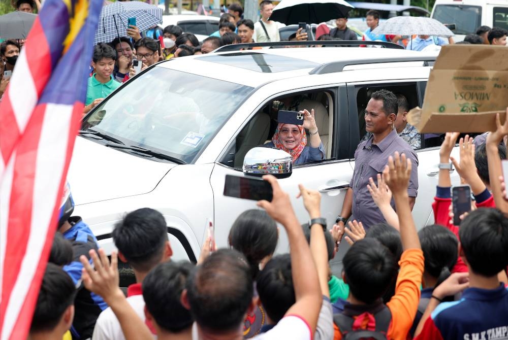 Tunku Azizah berkenan merakam video orang ramai ketika menuju ke Kota Kinabalu sempena Kembara Kenali Borneo hari ini. - Foto Bernama