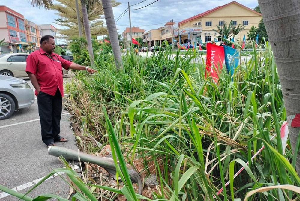 Jegaanathan menunjukkan keadaan parit yang ditumbuhi semak samun sehingga sering mengakibatkan banjir kilat di Simpang Jeram, Bakri, Muar pada Selasa.