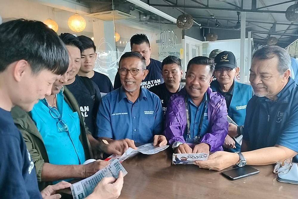 Mohd Solihan (kanan) dan Zulkifli (dua dari kanan) beramah mesra bersama jentera PN di Bukit Indah pada Rabu.