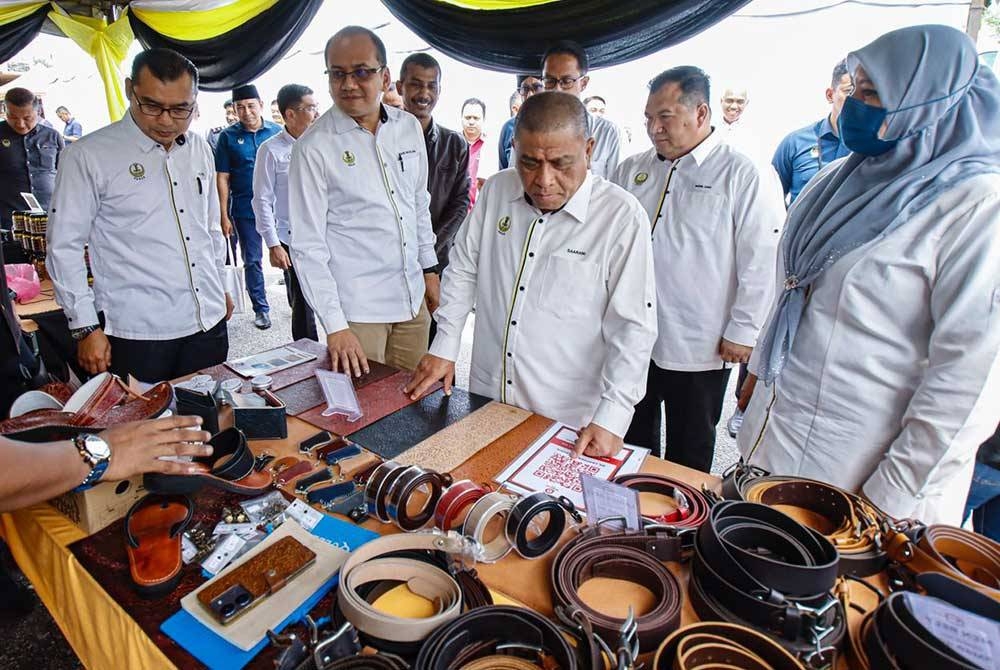 Saarani (tengah) melawat reruai jualan produk berasaskan kulit sebelum menghadiri majlis perasmian M-SL: Projek Kelulusan Pembinaan Secara Pintas Majlis Daerah Tanjong Malim pada Khamis.