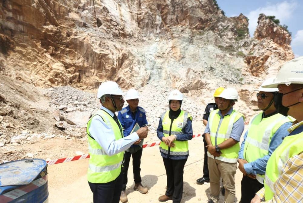 Sivanesan (kiri) meninjau lokasi kejadian runtuhan batu kapur yang menimpa pekerja kuari di Keramat Pulai dekat Simpang Pulai pada Jumaat.