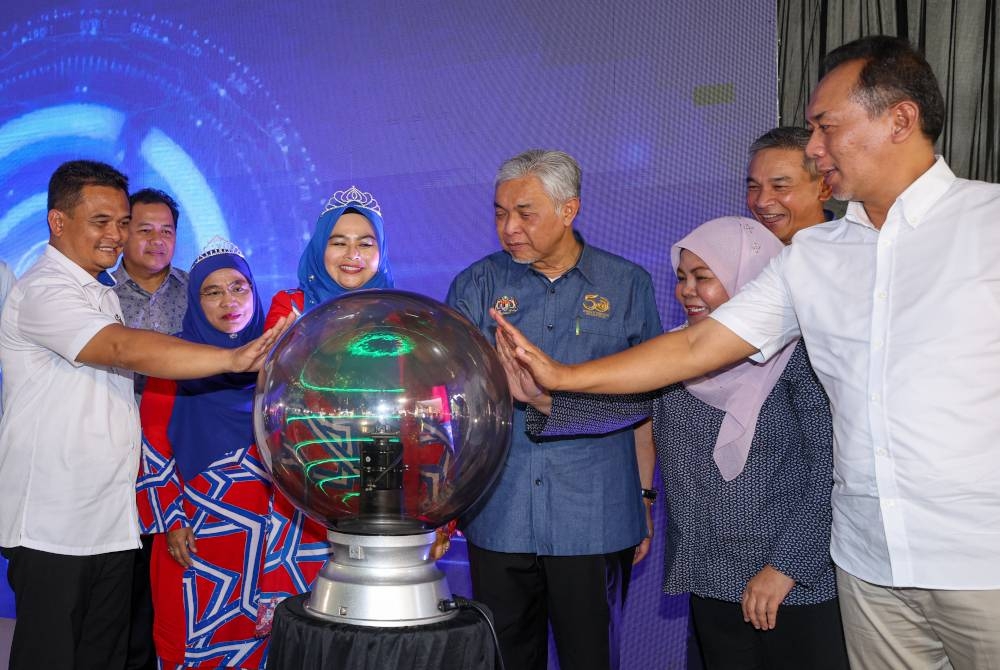 Ahmad Zahid (tengah) bersama Noraini (tiga dari kiri) melakukan gimik pelancaran pada Program Perasmian Karnival Usahawan Wanita di Maktab Rendah Sains MARA (MRSM) Batu Pahat, pada Jumaat. - Foto Bernama