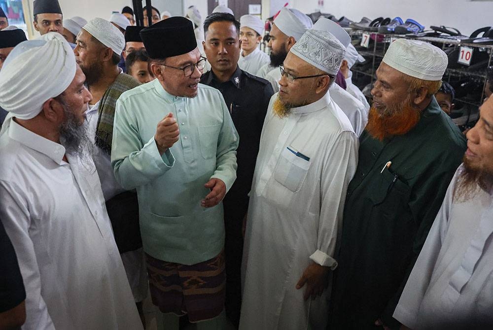 Anwar beramah mesra dengan jemaah masjid ketika hadir menunaikan solat Jumaat di Masjid Jamek Seri Petaling, pada Jumaat. - Foto Bernama