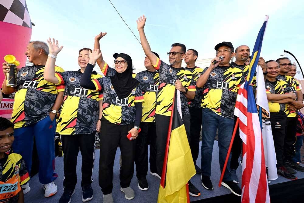 Jalaluddin (memegang Jalur Gemilang) bersedia melepaskan peserta acara FitMalaysia Peringkat Negeri Sembilan 2023.