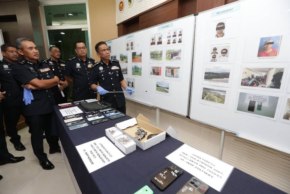 Fisol (kanan) menunjukkan gambar lima kumpulan sindiket penyeludupan pendatang asing tanpa izin (PATI) melibatkan 12 ejen sindiket warga tempatan dan Myanmar yang ditahan hasil Op Pintas baru-baru ini.