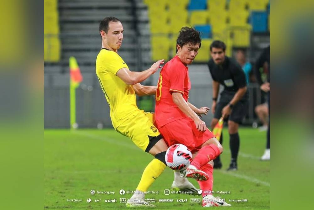 Kapten Malaysia, Dion Cools (kiri) cuba mengawal pemain China dalam aksi persahabatan di Chengdu pada Sabtu. - Foto Facebook FAM