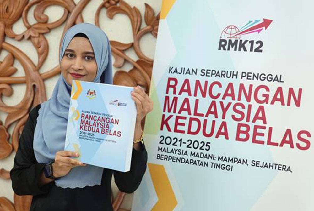 Kakitangan Kementerian Ekonomi, Nur Umairah Ramli menunjukkan buku KSP RMK12 bertemakan Malaysia Madani: Mampan, Sejahtera, Berpendapatan Tinggi di Bangunan Parlimen. - Foto Bernama