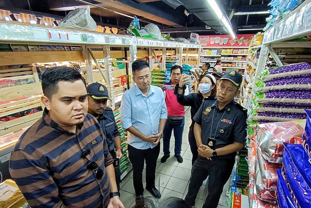 Dr Muhamad Akmal (kiri) dan Shoo Chin (dua, kiri) ketika membuat pemeriksaan mengejut bekalan beras pada Op Jamin di sebuah pasar raya di Jasin pada Selasa.