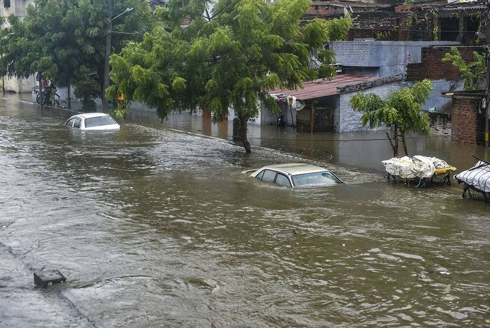 Kenderaan hampir tenggelam akibat banjir berikutan hujan lebat di Lucknow pada Khamis. - Foto: Agensi