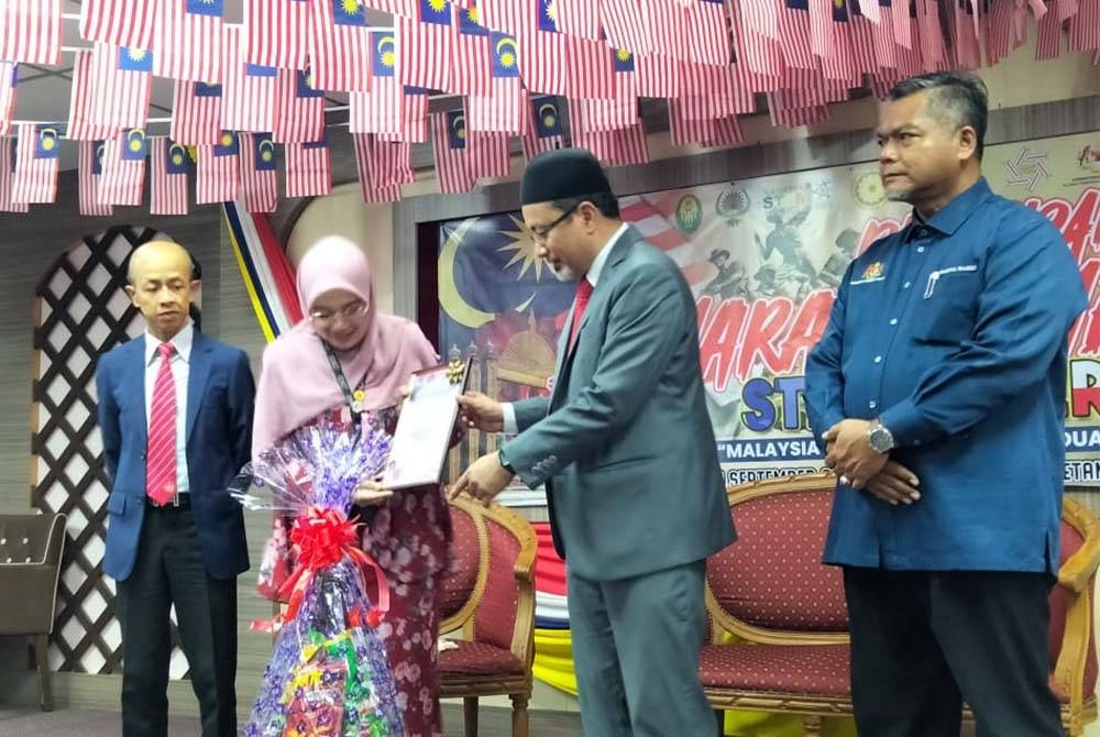 Zamakhshari (dua dari kanan) menyampaikan sijil kepada wakil agensi yang menyertai Program Semarak Kemerdekaan 2023: STEM@ Merdeka di Perpustakaan Awam Kelantan pada Rabu.