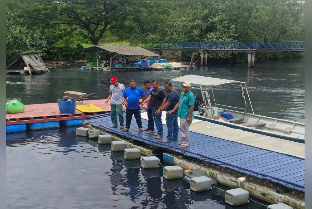 Nelayan menunjukkan kawasan perairan di Jeti Kampung Pasir Gudang Baru, Pasir Gudang yang berwarna hitam dan mengeluarkan bau busuk.