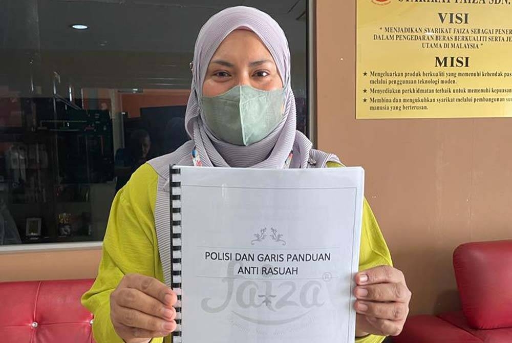 Norliza Radin menunjukkan buku polisi dan garis panduan antirasuah Syarikat Faiza.