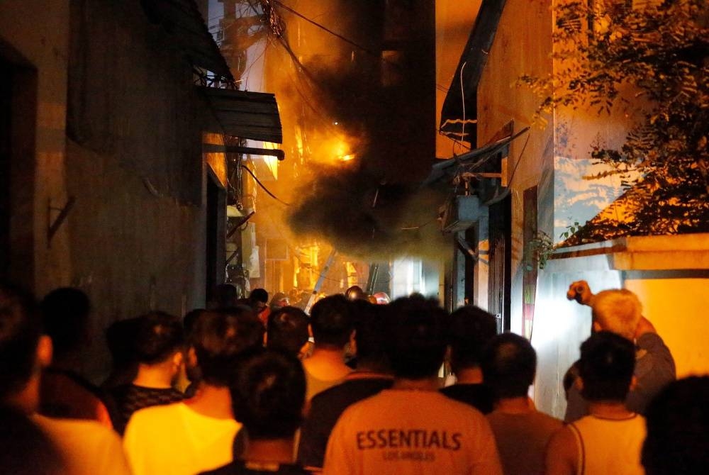 Kebakaran sebuah blok pangsapuri di Hanoi, Vietnam telah mengorbankan 56 orang setakat petang Rabu. - Foto AFP