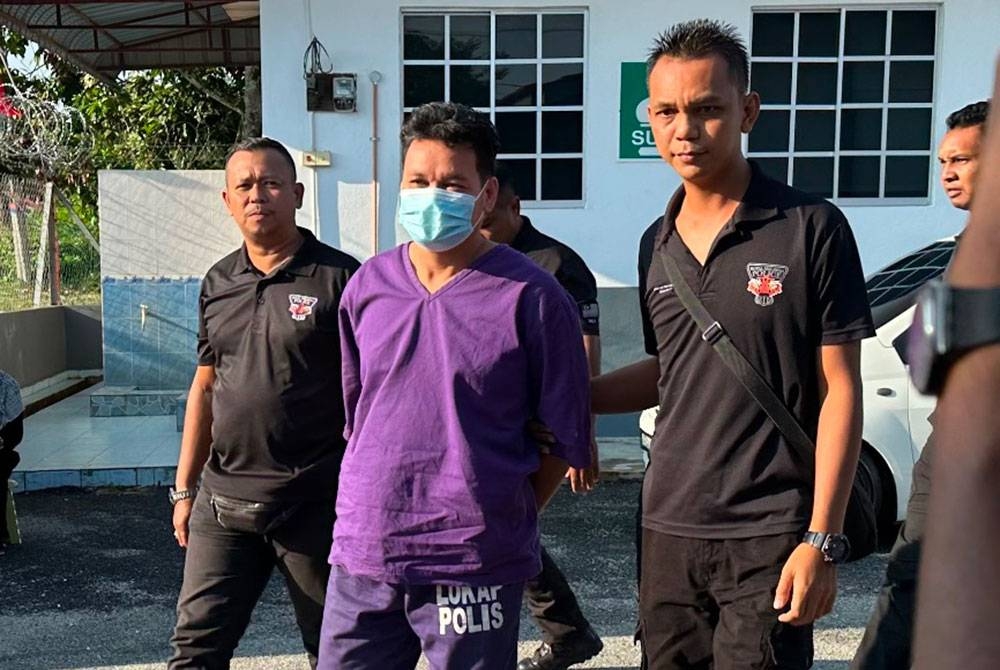 Harun Narresat (tengah) dikawal ketat polis ketika tiba di mahkamah pada Khamis.