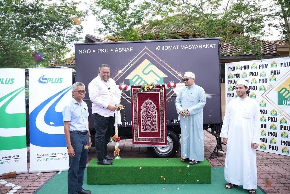 Mohamad Wadi Annuar (dua dari kanan) menyerahkan sejadah simbolik Program Infak Sejadah kepada Mohd Kasim (dua dari kiri) di Hentian Rehat dan Rawat Bukit Gantang, Taiping. - Foto ihsan PKU