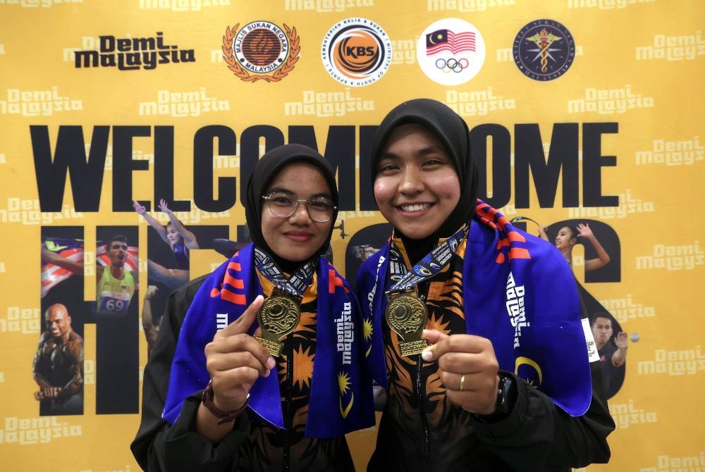 Nur Ain Nabilah (kanan) dan Aleen bersama medal selepas dimenangi selepas menjuarai acara pairs wanita Kejohanan Boling Padang Dunia di Gold Coast, Austalia pada Sabtu lalu. - Foto Bernama