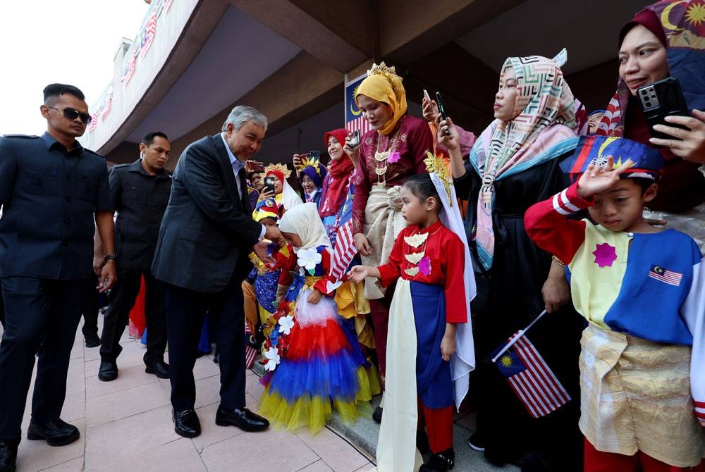 Ahmad Zahid menyantuni kanak-kanak Tabika Kemas pada majlis penutupan Kembara Merdeka Desa Madani 2023 di Dataran Gemilang, pada Jumaat. - Foto Bernama