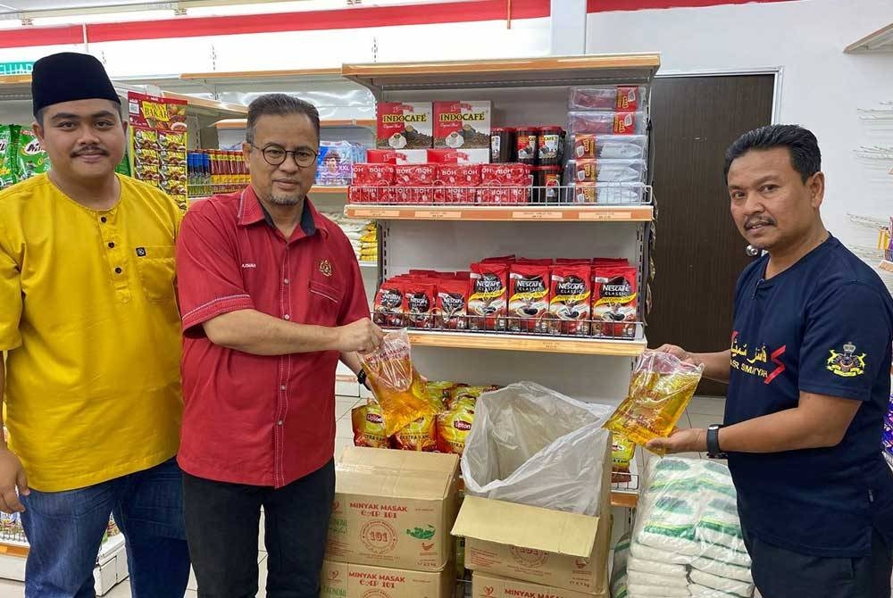 Azman (dua,kiri) bersama ahli jawatankuasa KSKK KPDN Kelantan menunjukkan sebahagian daripada barangan kawalan dan keperluan harian yang dijual dengan harga berpatutan.