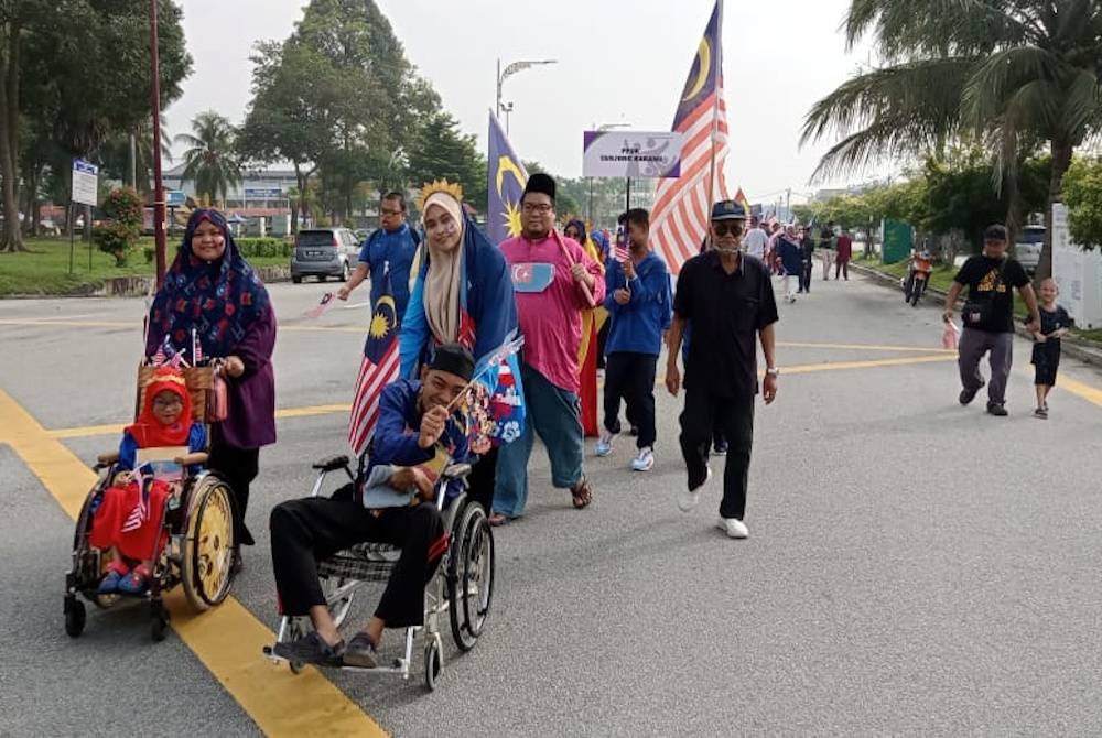 Sebahagian OKU yang menyertai perarakan sejauh dua kilometer pada Program Sambutan Hari Kemerdekaan dan Hari Malaysia dekat sini.