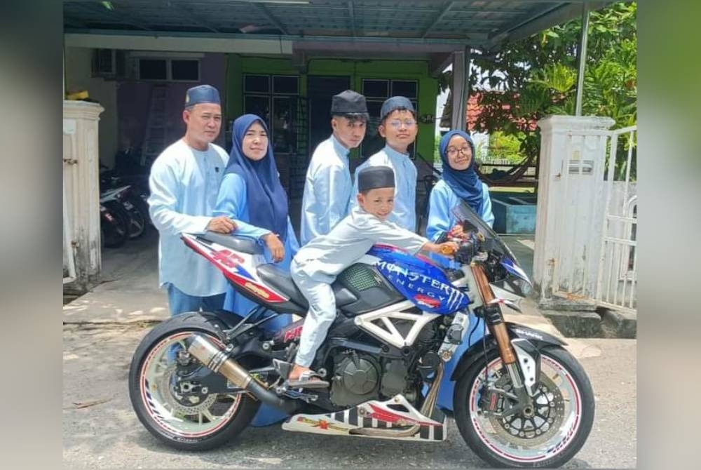 Gambar sekeluarga yang dirakamkan sempena Aidilfitri lalu, bersama motosikal milik Ridzuan sebelum dicat semula.