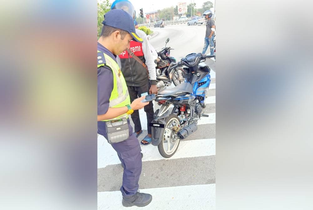 Anggota JPJ memeriksa sebuah motosikal yang menggunakan plat yang kecil. - Facebook JPJ Pulau Pinang