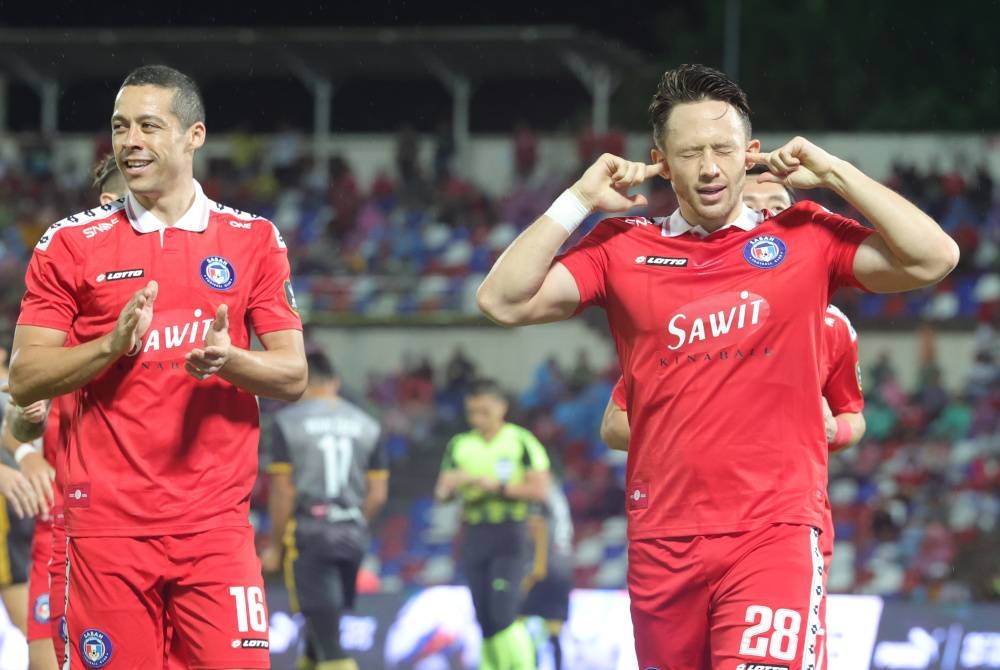 Pemain Sabah FC, Darren Lok (kanan) meraikan jaringannya pada saingan Piala Malaysia menentang Perak FC di Stadium Likas pada Jumaat. - Foto Bernama