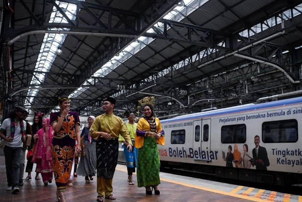 Peserta yang menggayakan pakaian tradisional dan kain batik atau sarong ketika Keretapi Sarong 2022. - Foto: Bernama