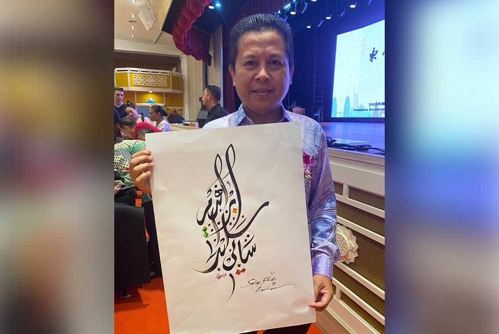 Abdul Baki menunjukkan seni kaligrafi jawi hasil karyanya.