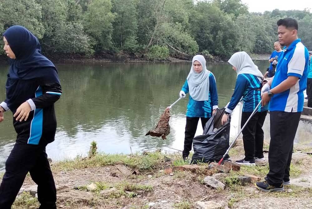 Pihak sukarelawan mengutip sampah di pinggir sungai pada program berkenaan.