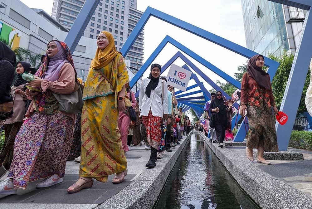 Peserta mengenakan kain sarong dan pelikat membanjiri sepanjang laluan pejalan kaki Sungai Segget pada program Keretapi Sarong 2023 (KS2023) sempena Hari Malaysia pada Sabtu. - Foto Bernama